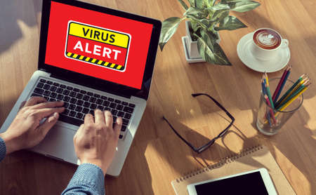 Virus Alert Warning Digital Browsing Concept man hand on table Business, coffee, Split toneの写真素材