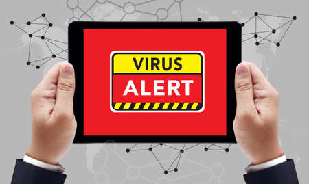 Virus Alert Warning Digital Browsing Concept on the tablet pc screen by businessman hands, top viewの写真素材
