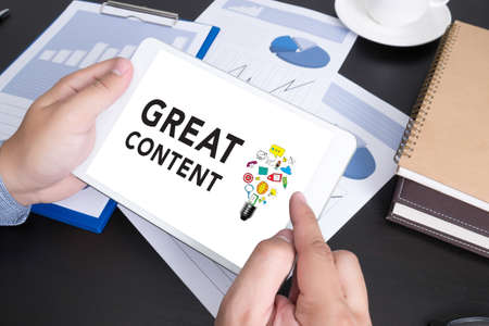 Modern people doing business, graphs and charts being demonstrated on the screen of a touch-pad, GREAT CONTENTの写真素材