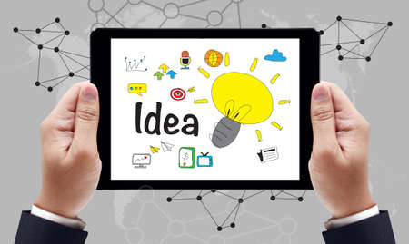Ideas Idea Design Concept on the tablet pc screen by businessman hands, top viewの写真素材