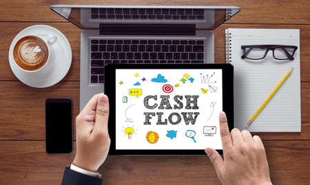 CASH FLOW CONCEPT , on the tablet pc screen held by businessman hands - online, top viewの写真素材