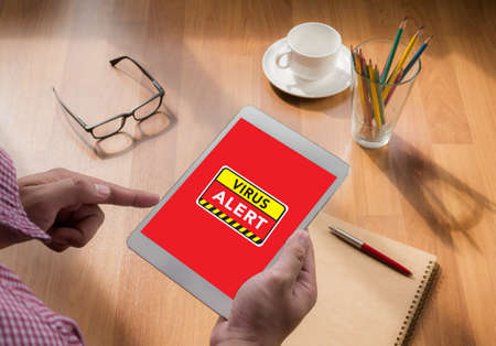 Virus Alert Warning Digital Browsing Concept touch digital tablet, coffeeの写真素材