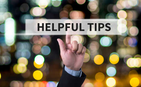 HELPFUL TIPS CONCEPT Business man with hand pressing a button on blurred abstract backgroundの写真素材