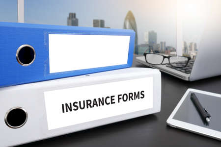 INSURANCE FORMS CONCEPT  Office folder on Desktop on table with Office Supplies.の写真素材