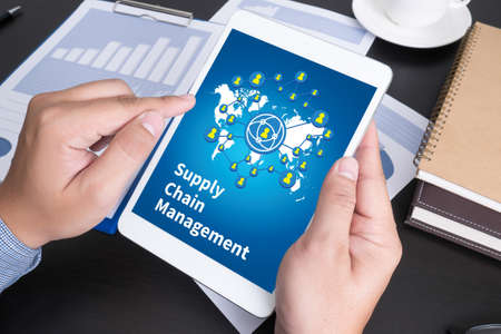 SCM Supply Chain Management concept Modern people doing business, graphs and charts being demonstrated on the screen of a touch-pad,の写真素材