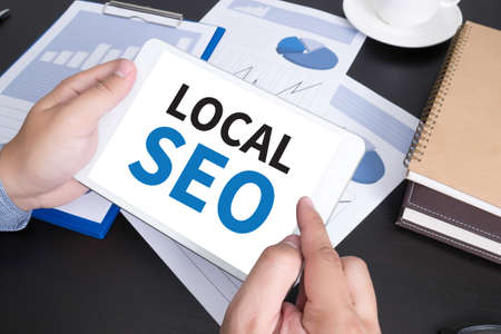 Local SEO Concep Modern people doing business, graphs and charts and touch-padの写真素材