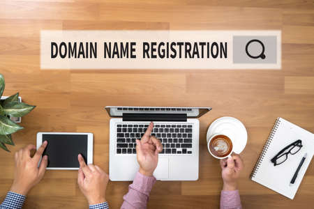 DOMAIN NAME REGISTRATION Two Businessman working at office desk and using a digital touch screen tablet and use computerの写真素材