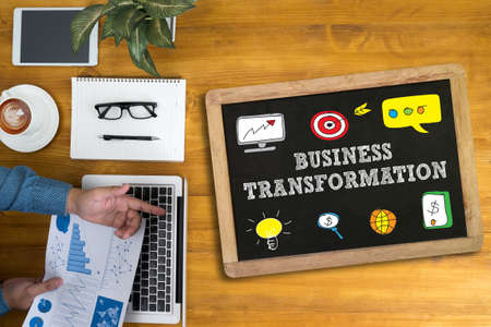 BUSINESS TRANSFORMATION Businessman working at office desk and using computer and objects, coffee, top view,の写真素材