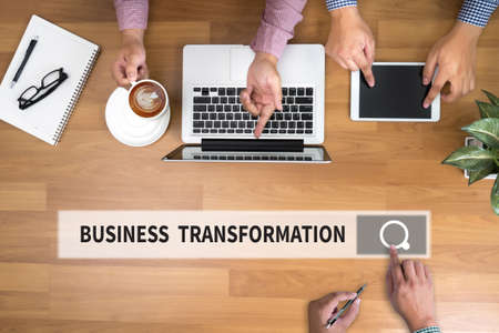 BUSINESS TRANSFORMATION man touch bar search and Two Businessman working at office desk and using a digital touch screen tablet and use computer objects on the right, top viewの写真素材