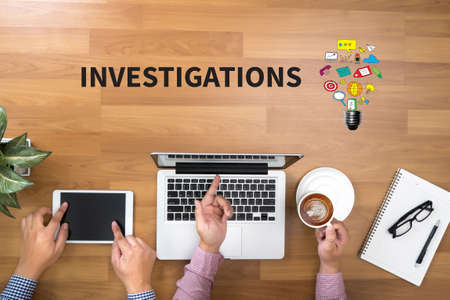 INVESTIGATIONS CONCEPT        Two Businessman working at office desk and using a digital touch screen tablet and use computer objects on the right, top view copy spaceの写真素材