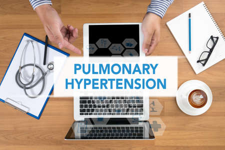 PULMONARY HYPERTENSION Doctor touch digital tablet, desktop with medical equipment on background, top view, coffeeの写真素材