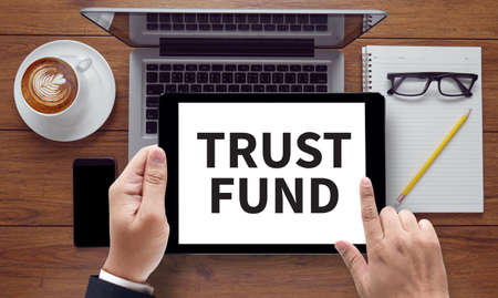 TRUST FUND , on the tablet pc screen held by businessman hands - online, top viewの写真素材