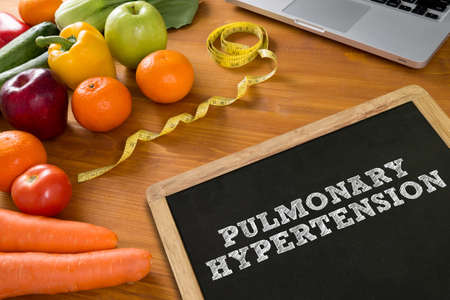 PULMONARY HYPERTENSION Fitness and weight loss concept, fruit and tape measure on a wooden table, top viewの写真素材