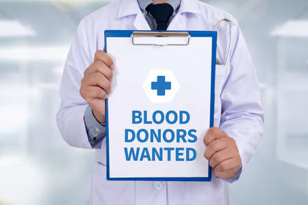 BLOOD DONORS WANTED Portrait of a doctor writing a prescriptionの写真素材