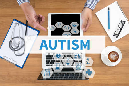 AUTISM CONCEPT Doctor touch digital tablet, desktop with medical equipment on background, top view, coffeeの写真素材