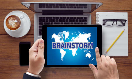 BRAINSTORM, on the tablet pc screen held by businessman hands - online, top viewの写真素材