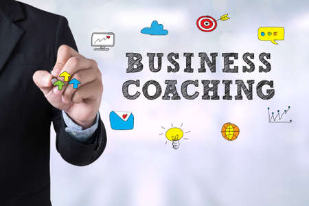 BUSINESS COACHING Businessman drawing Landing Page on blurred abstract backgroundの写真素材