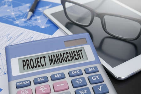 PROJECT MANAGEMENT Calculator  on table with Office Supplies. ipadの写真素材