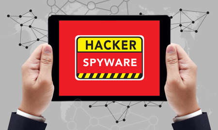 Warning Spyware Concept on the tablet pc screen by businessman hands, top viewの写真素材