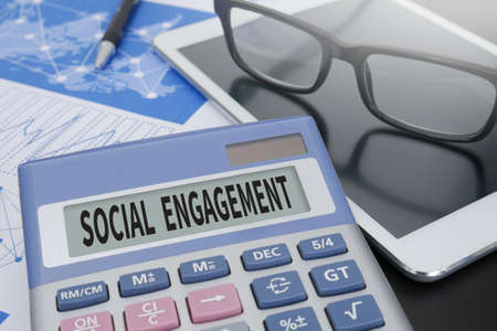 SOCIAL ENGAGEMENT Calculator  on table with Office Supplies. ipadの写真素材