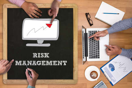 RISK MANAGEMENT Concept Businessman working at office desk and using computer and objects on the right, coffee,  top view,の写真素材