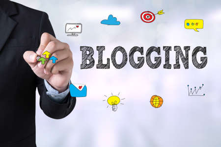 BLOGGING Businessman drawing Landing Page on blurred abstract backgroundの写真素材