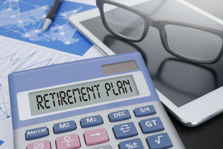 RETIREMENT PLAN Calculator  on table with Office Supplies. ipadの写真素材