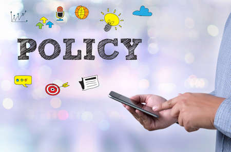 POLICY person holding a smartphone on blurred cityscape backgroundの写真素材