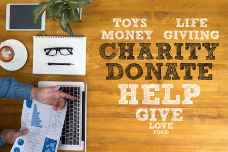 CHARITY DONATE Give Concept Businessman working at office desk and using computer and objects, coffee, top view,の写真素材