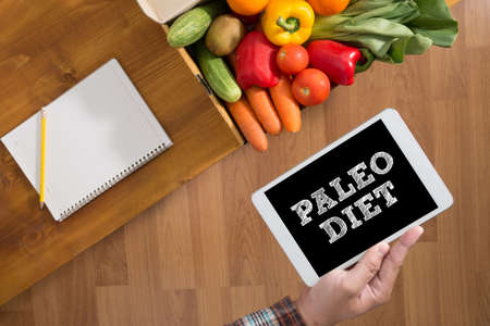 PALEO DIET Touch screen digital tablet, fresh vegetables and grass on a wooden tableの写真素材