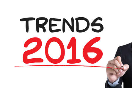 TRENDS 2016 Businessman hand writing with black marker on white backgroundの写真素材