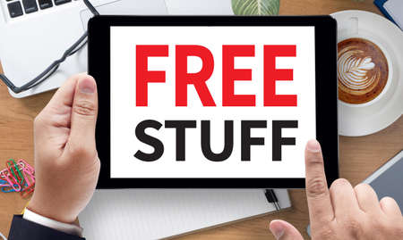FREE STUFF, on the tablet pc screen held by businessman hands - online, top view