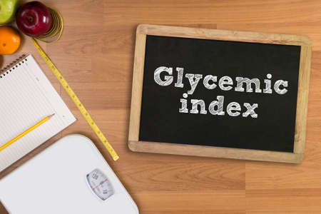 Glycemic index Fitness and weight loss concept, dumbbells, white scale, fruit and tape measure on a wooden table, top view, free copy spaceの写真素材