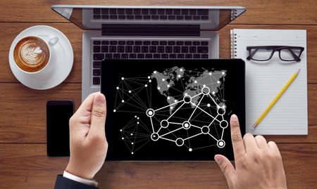 IOT hands at work with financial reports and a laptop with other objects around, coffee, top...