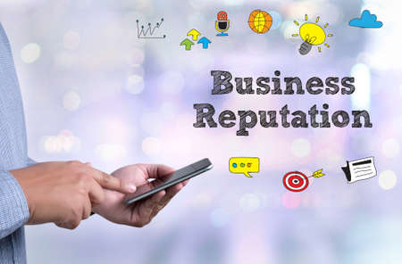 Business Reputation  person holding a smartphone on blurred cityscape backgroundの写真素材