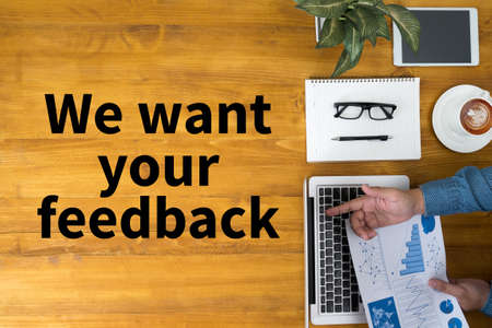 We want your feedback Businessman working at office desk and using computer and objects, coffee, top viewの写真素材