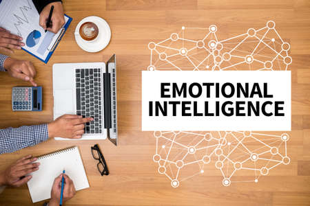 EMOTIONAL INTELLIGENCE Business team hands at work with financial reports and a laptop EMOTIONAL INTELLIGENCE Business team hands at work with financial reports and a laptop