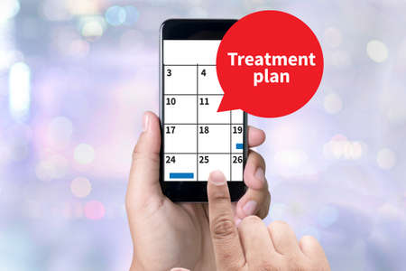 Treatment plan person holding a smartphone on blurred cityscape backgroundの写真素材