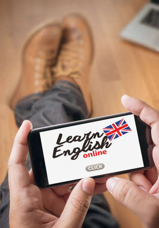 Learn English Thoughtful male person looking to the digital phone screen,Silhouette top computer and handの写真素材