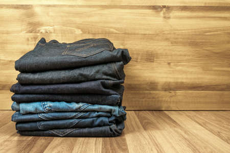 Blue jeans on a brown wooden background and Blue jeans denim Collection jeans stackedの写真素材