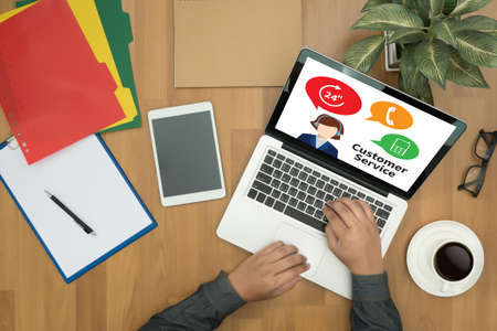 THE CUSTOMER SERVICE and Customer Service Call Center Agent Care (Target Market Support Assistance) businessman working   on office table with digital tablet and man working with smart laptop computer top viewの写真素材