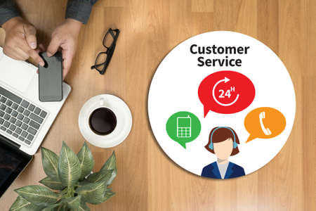 THE CUSTOMER SERVICE and Customer Service Call Center Agent Care (Target Market Support Assistance) Hipster wooden desktop with laptop, office accessories, flat lay top viewの写真素材