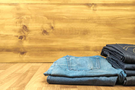 Blue jeans on a brown wooden background and Blue jeans denim Collection jeans stackedの写真素材