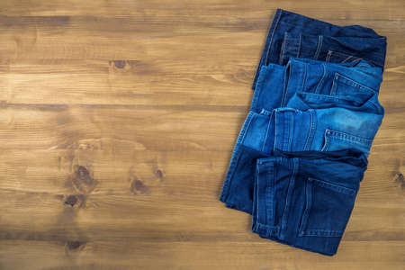Blue jeans on a brown wooden background and Blue jeans denim Collection jeans stackedの写真素材