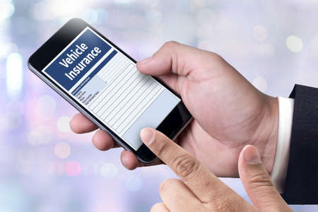 Form Document Vehicle Insurance Claim  person holding a smartphone on blurred cityscape backgroundの写真素材