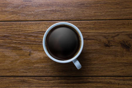 White cup of coffee on vintage wood. Top view ,  cup on wooden table. View from top ,   break or breakfastの写真素材