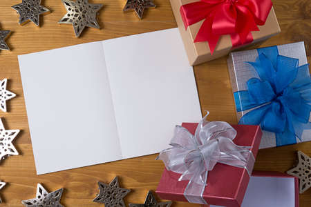Top view and gift box and red ribbon with card on table wooden.