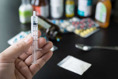 Pharmaceutical medicament, cure in container for health Drug syringe and cooked heroin on spoonの写真素材