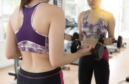 woman use dumbbell fitness exercise in gym