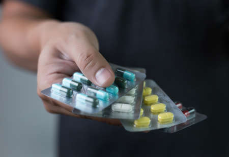 man Hand holding medicine pack at the pharmacy  Variety of medicines and drugsの写真素材